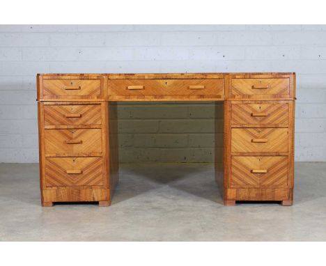 A Maple & Co. Art Deco walnut pedestal desk, c.1925, the inverted breakfront top with an inset brown leather writing surface,