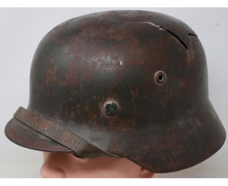 A German WWII M42 helmet with leather liner, retaining original paint, with later applied SS decals, named to interior, crown