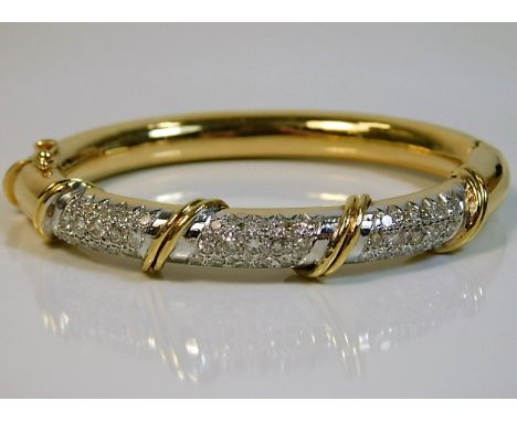 An 18ct gold bangle set with approx. 3ct of diamond 30.9g