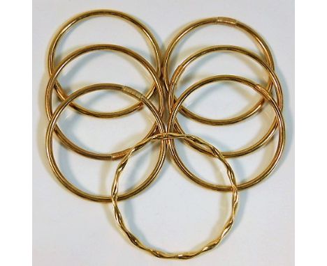 Six plain 9ct gold bangles twinned with one yellow metal bangle (tests as 9ct gold) 43.6g