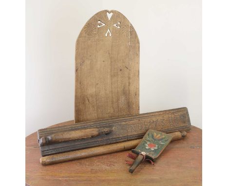 A Swedish softwood ironing board,carved 'B.M.D. ANO MDCCCXIX' (1819) below the arched top with pierced and carved roundels,29