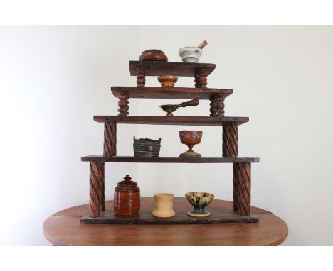 A folk art wall display, predominantly 19th century, Swedish, with painted pine hanging shelves, the five graduated platforms