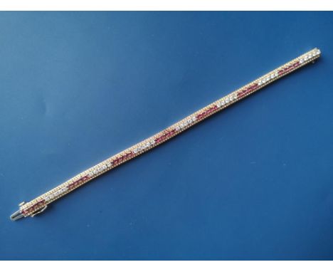 A ruby &amp; diamond set line bracelet , having a central line of round cut stones arranged in alternating coloured groups of