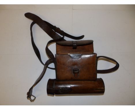 A Victorian leather pouch containing a silver sandwich tin - London 1885 , 6" across and a plated flask with drinking cup.