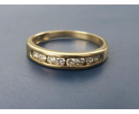 A diamond set yellow metal half eternity ring. Finger size L/M.