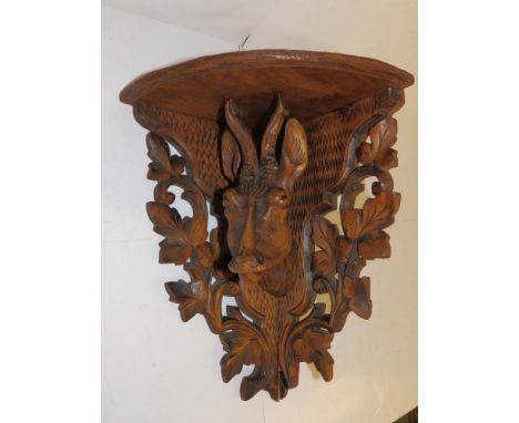 A Black Forest antelope head corner shelf bracket, 15" high.