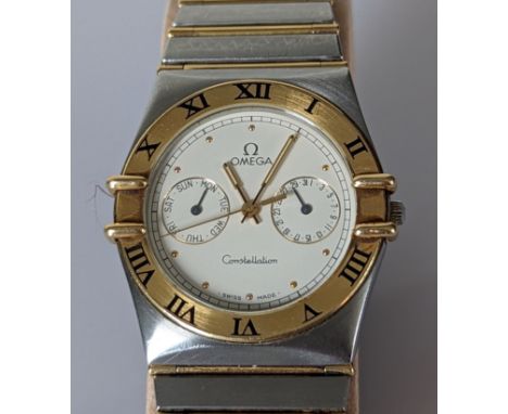 An Omega Quartz Day Date Constellation wristwatch with white dial, dot hour marks, gold bezel, stainless steel and 18ct yello