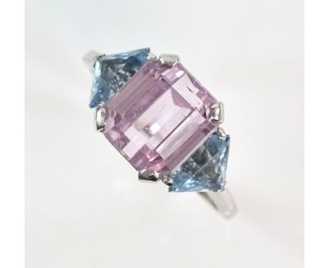 Vintage dress ring set with an emerald cut pink Kunzite stone bordered by two aquamarine stones in unmarked white metal testi