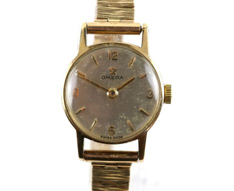 Omega ladies gold  dress watch the silvered dial with baton hour markers, ,with Arabic numerals  to 1,3,6 and 9. Fitted with 