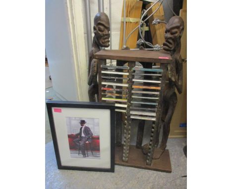 A vintage carved wooden CD rack fashioned as tribal art African figures and a print 