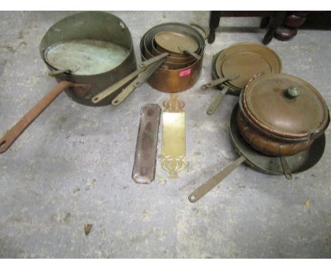 A selection of early 20th century copper cooking pans, brass door finger plates and other items 