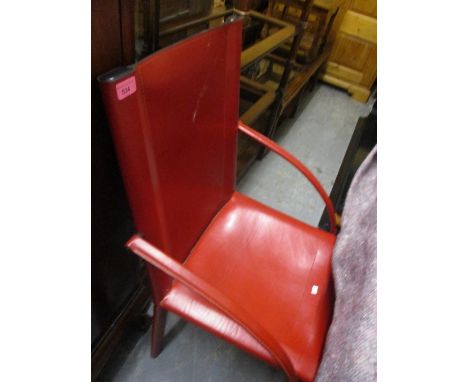 A red leather upholstered armchair, together with a wicker twin handled trunk 