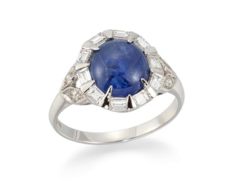 A sapphire and diamond ring, of cluster design, with an oval cabochon sapphire to surround of baguette cut diamonds, split br