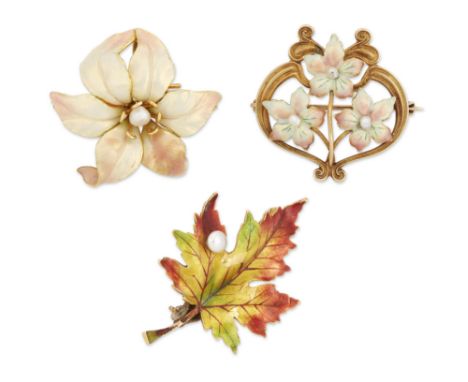 Three American enamel and pearl brooches, early 20th century, two of floral design, the third in the form of a maple leaf, on