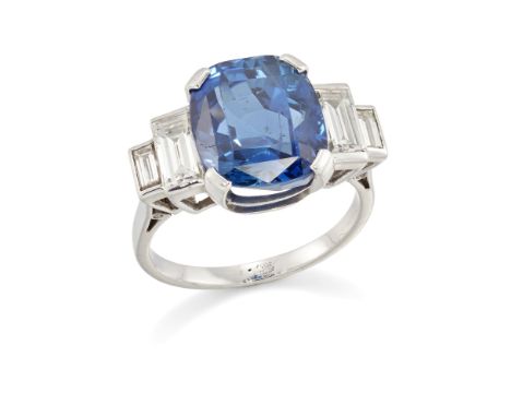 A sapphire and diamond ring, the cushion cut sapphire, approximately 11.7 x 10.4 x 7.7mm, claw set with a pair of graduated b