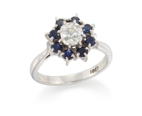 A diamond and sapphire cluster ring, with an old cut diamond to surround of circular cut sapphires, all claw set to a plain h