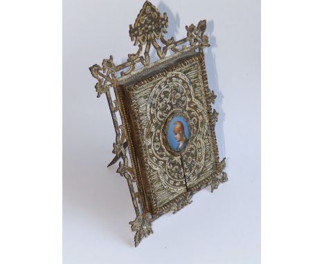 A 19thC Italian painted gilt metal strut picture frame in Renaissance Revival style, set to centre of folding doors with an o