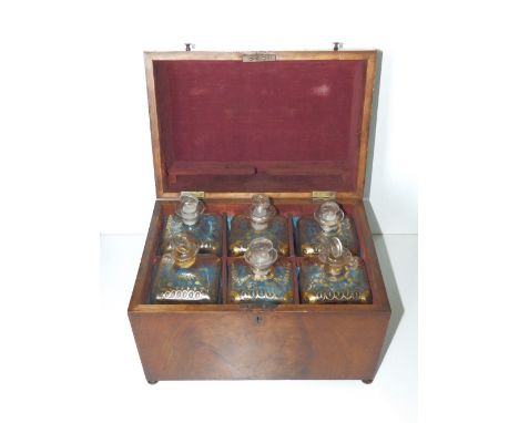 A 19thC Dutch mahogany decanter case, containing six square bottles with gilded shoulders11.75” across