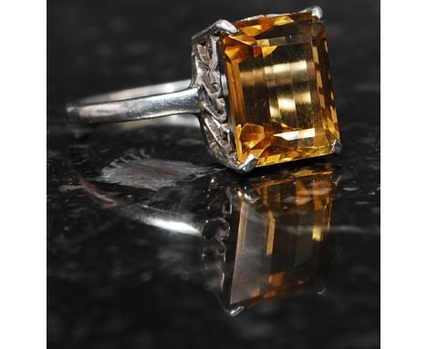 A silver 925 and citrine stone cocktail / dress ring. The cushion cut citrine with claw mount and scroll worked sides. Total 