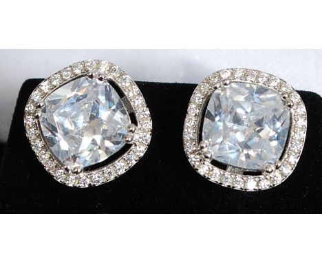 A pair of white metal silver 925 and cz stud earrings. The cushion cut stones with borders set on fret worked mount

FREE UK 