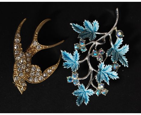 A ladies pave set diamonte gilded metal brooch in the form of a swallow together with a enamel set rhinestone maple leaf broo
