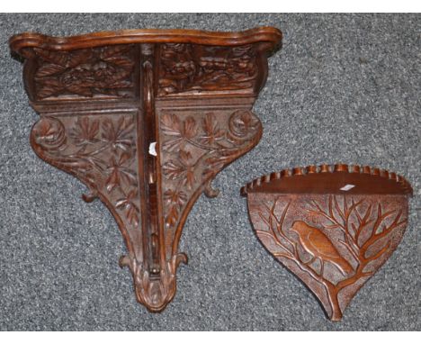 Carved oak wall shelf having carved shamrock and foliate decoration. Together with another smaller carved shelf with a bird a