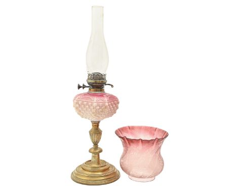 A Victorian brass oil lamp, with shaded pink moulded glass fount of cut cornered square form, brass burner and an etched and 