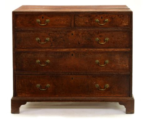 A George III oak chest of drawers, the brass handles apparently original, 95cm h; 53 x 105cm  The three boards to the top sli