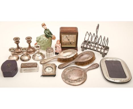 An Edwardian silver three piece brush set, one and two pairs of dwarf silver candlesticks, silver photograph frame, a silver 