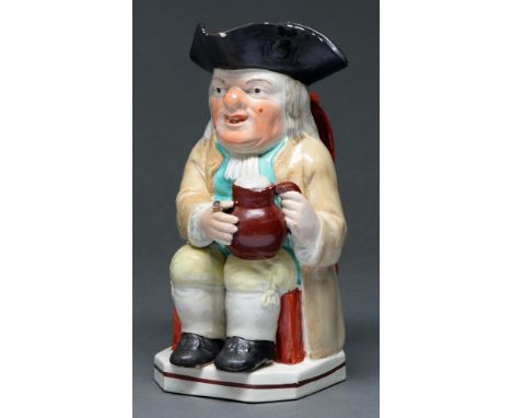 A Staffordshire Toby jug, c1820,&nbsp; the seated toper holding a foaming jug of ale, wearing a light brown coat, turquoise w