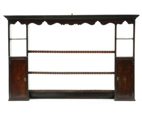 A George III oak dresser rack, with dentil cornice and open shelves flanked by spice cupboards with crossbanded doors and cen