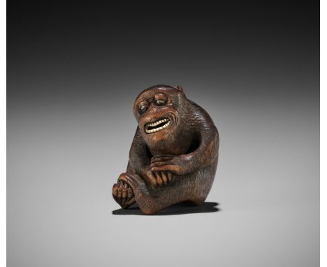 A HUMOROUS WOOD NETSUKE DEPICTING A SMILING MONKEYSchool of Kano Tomokazu, unsigned Japan, Gifu, mid-19th century, Edo period