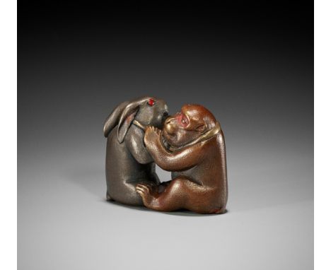 A RARE LACQUERED NETSUKE OF A MONKEY AND HARE ENGAGED IN KUBIHIKI (NECK WRESTLING)Unsigned Japan, Meiji period (1868-1912)Fin