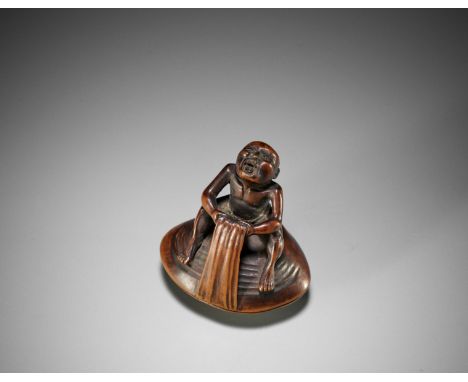 GYOKUTEI: A WOOD SHUNGA NETSUKE OF MAN ON HAMAGURI CLAMBy Gyokutei, signed Gyokutei 玉亭Japan, Edo (Tokyo), first half of 19th 