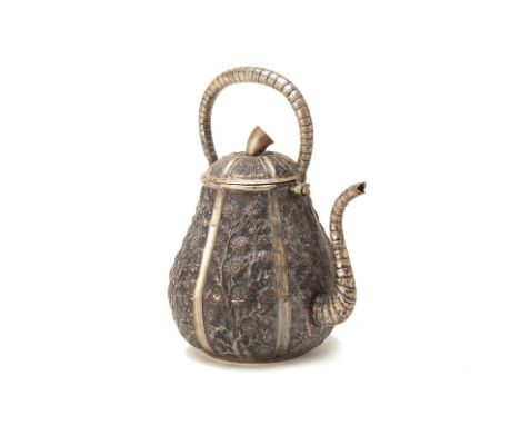 A VIETNAMESE WHITE METAL TEAPOT
With foliate decoration in relief to the body and cover, the spout curved and finial in the s