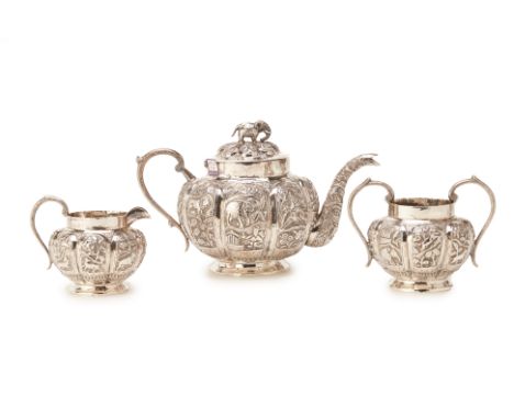 AN INDIAN SILVER THREE PIECE TEA SERVICE
With panelled repousse decoration depicting elephants, lions, deers and figures amon