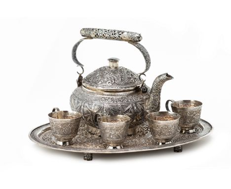 A VIETNAMESE WHITE METAL TEA SERVICE
Comprising: an oval tray, chased with a dragon and phoenix to the centre within multiple