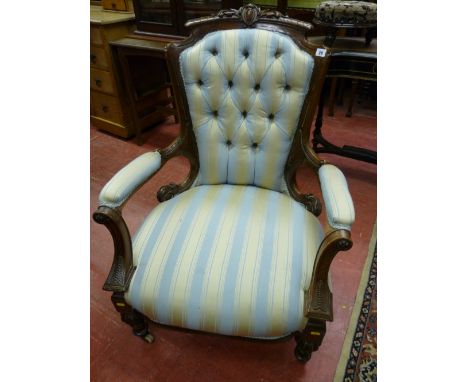 A VICTORIAN CARVED WALNUT BUTTON BACKED SALON ARMCHAIR, upholstered in a classical Regency stripe, 97 cms high, 71 cms wide