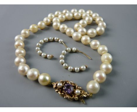 A NATURAL PEARL NECKLACE of non-graduated pearls with a fine nine carat gold scrolled clasp with centre amethyst and flanking
