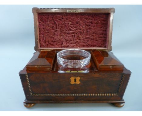 A VICTORIAN SARCOPHAGUS SHAPED WALNUT TEA CADDY with beaded decoration on turned bun feet, the interior with velvet lined lid