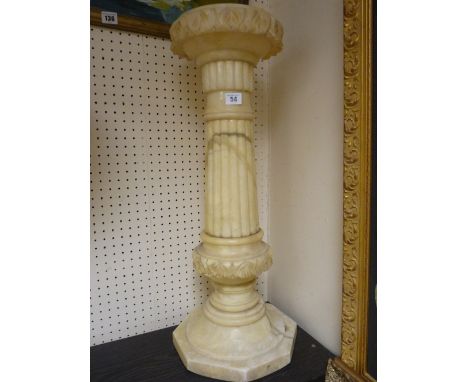 A CARVED ALABASTER CIRCULAR TOPPED STAND, the 23 cms diameter top with inverted leaf carving on a turned and reeded column an