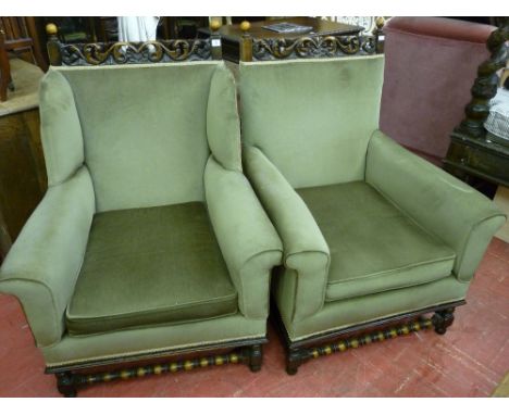 A GOOD PAIR OF OAK AND UPHOLSTERED ARMCHAIRS having leaf carved top rails with bobbin finials, green upholstery with block an