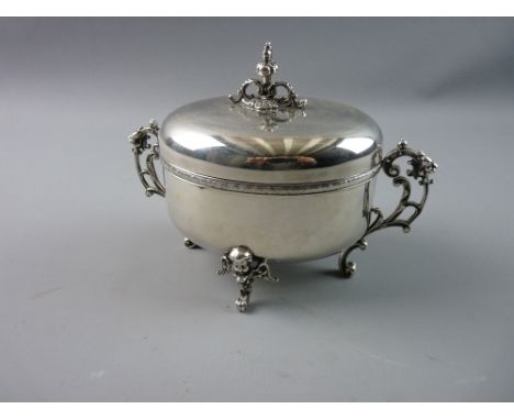 A CONTINENTAL WHITE METAL SUGAR BOX AND COVER, the hinged and engraved lid with Rococo finial, lion mask scroll handles termi