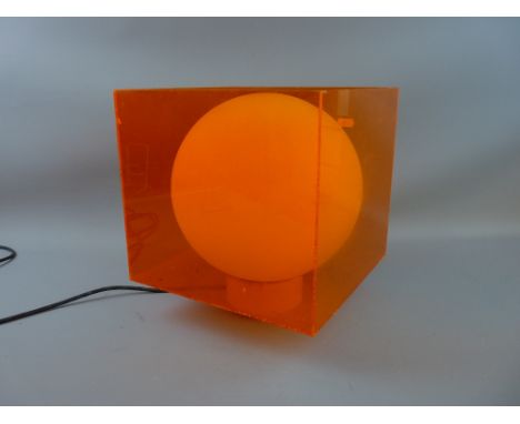 A RETRO TABLE LAMP circa 1960, orange perspex with white globular glass interior, 30.5 cms high with 25 x 26.5 cms panels (so