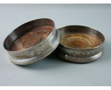 A PAIR OF WOODEN BASED CIRCULAR SILVER WINE COASTERS with garland decoration in the classical style, Sheffield 1981