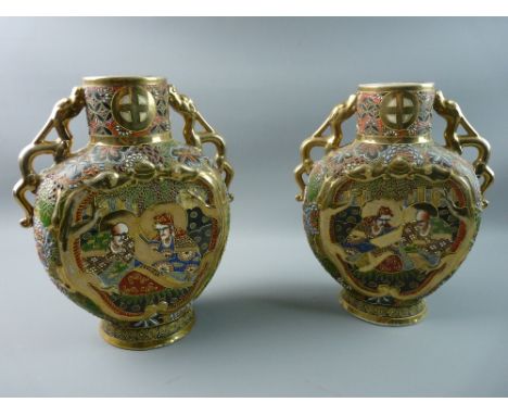 A PAIR OF 20th CENTURY JAPANESE SATSUMA VASES having all over raised enamel and gilt decoration showing panels of lohans and 
