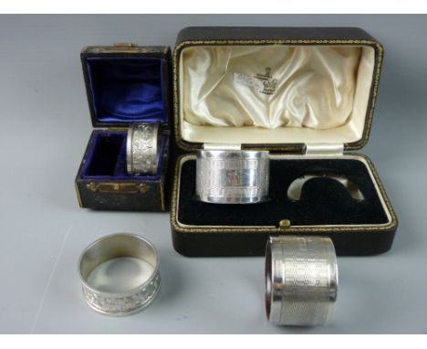 TWO CASED PAIRS OF HALLMARKED SILVER NAPKIN RINGS, a leaf chased pair, Birmingham 1902, 1.2 troy ozs and Birmingham 1952, eng