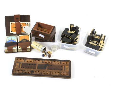 An assortment of vintage games. Comprising two domino sets (incomplete), a cribbage board, two packs of cards in a leather wa