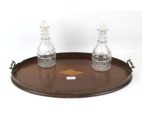 A 19th century twin handled mahogany tray and a pair of decanters. The tray of oval form with inlay modelled as a shell, L55c