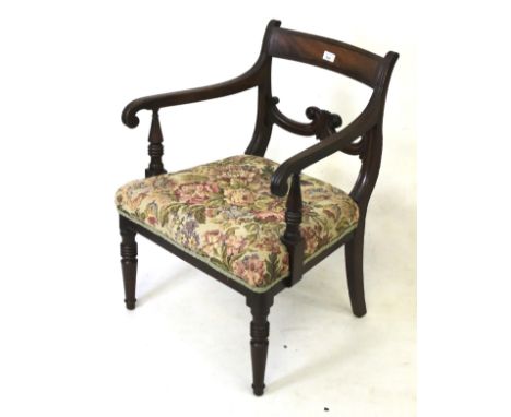 A Victorian mahogany carver open armchair. On turned tapering supports, floral tapestry seat and fluted decorated scroll arms